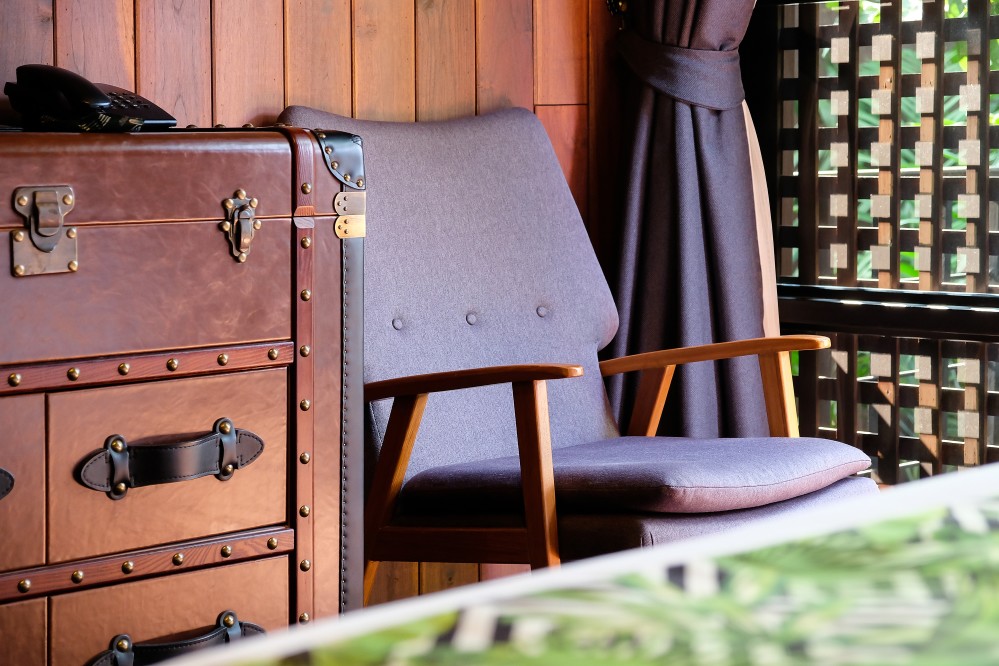 entretien meuble bois : mains nettoyant un meuble en bois verni avec un chiffon doux